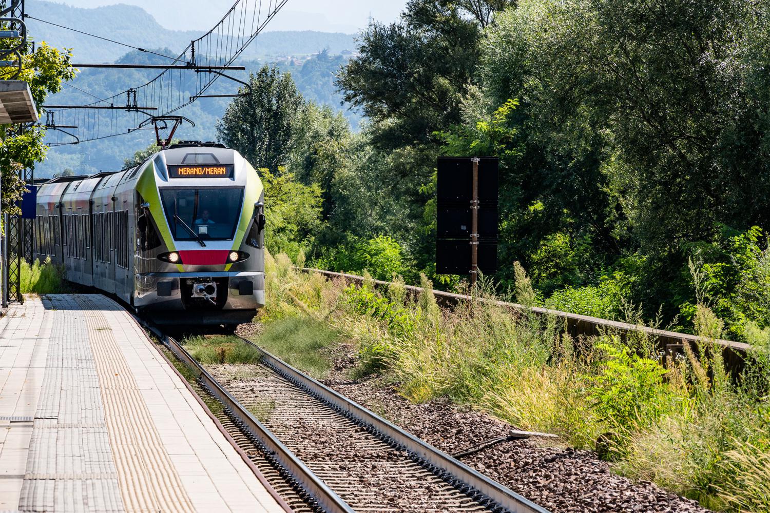 Zug fährt im Bahnhof Meran ein